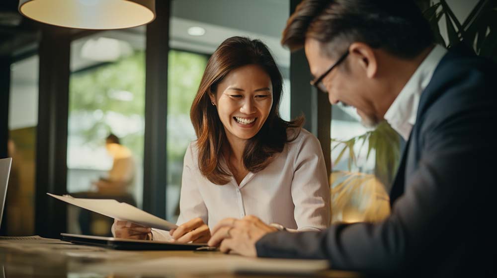 An interior designer smiling and discussing office layout design in a modern office setting with her client